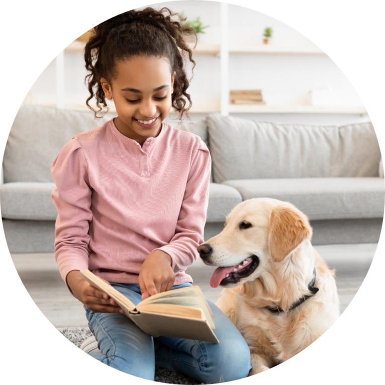 Smiling child reading to a dog